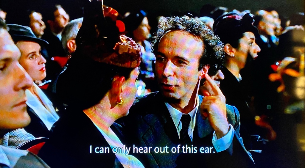 Roberto Begnini character from Life is Beautiful claiming that he can only hear out of one ear when looking towards the woman beside him at the opera.